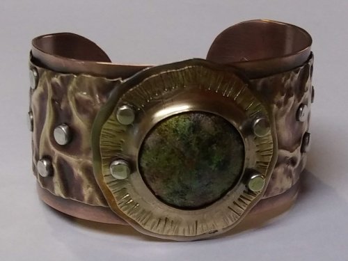 Judy Larson's Fold Formed Cuff With Faux Roman Glass or Coin Cabochon - , Metalwork, Cutting, Cutting Tool, Cutters, Dapping, Dapping Jewelry, Filing, Finishing, Forging, Forging Jewelry, Jewelry Forging, How To Punch Holes, Hole Punching, Punch A Hole, Oxidizing Wire, Oxidizing, Antiquing Wire, Antiquing, Riveting, Riveting Techniques, Wire Rivets, Sawing, Saw, Wire Saw, Texturing, Drilling, Drill, Fold Formed Faux Roman Glass Cuff